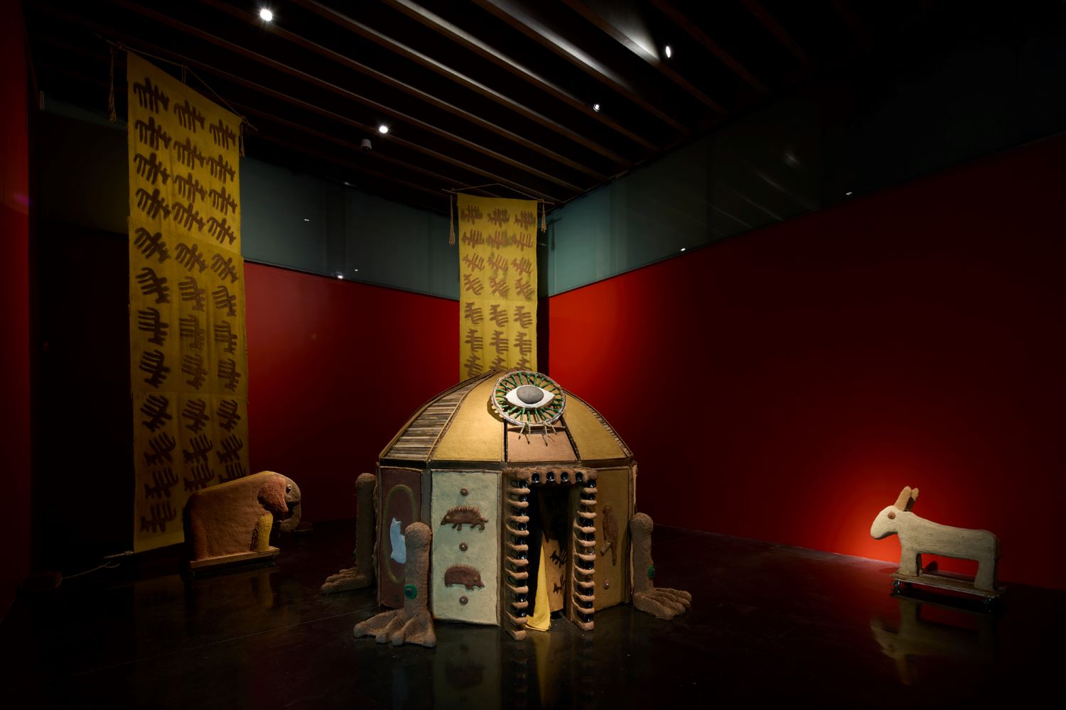 Art installation featuring a mud hut, elephant and donkey