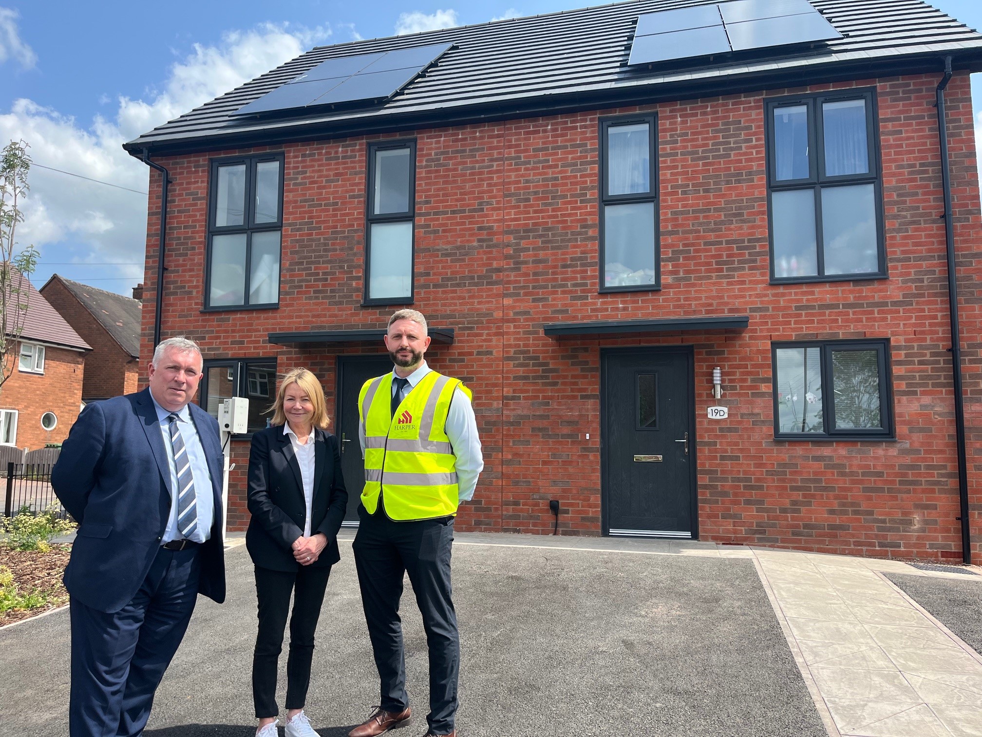 Cllr Andrew, whg and contractor standing outside new build house on margam crescent