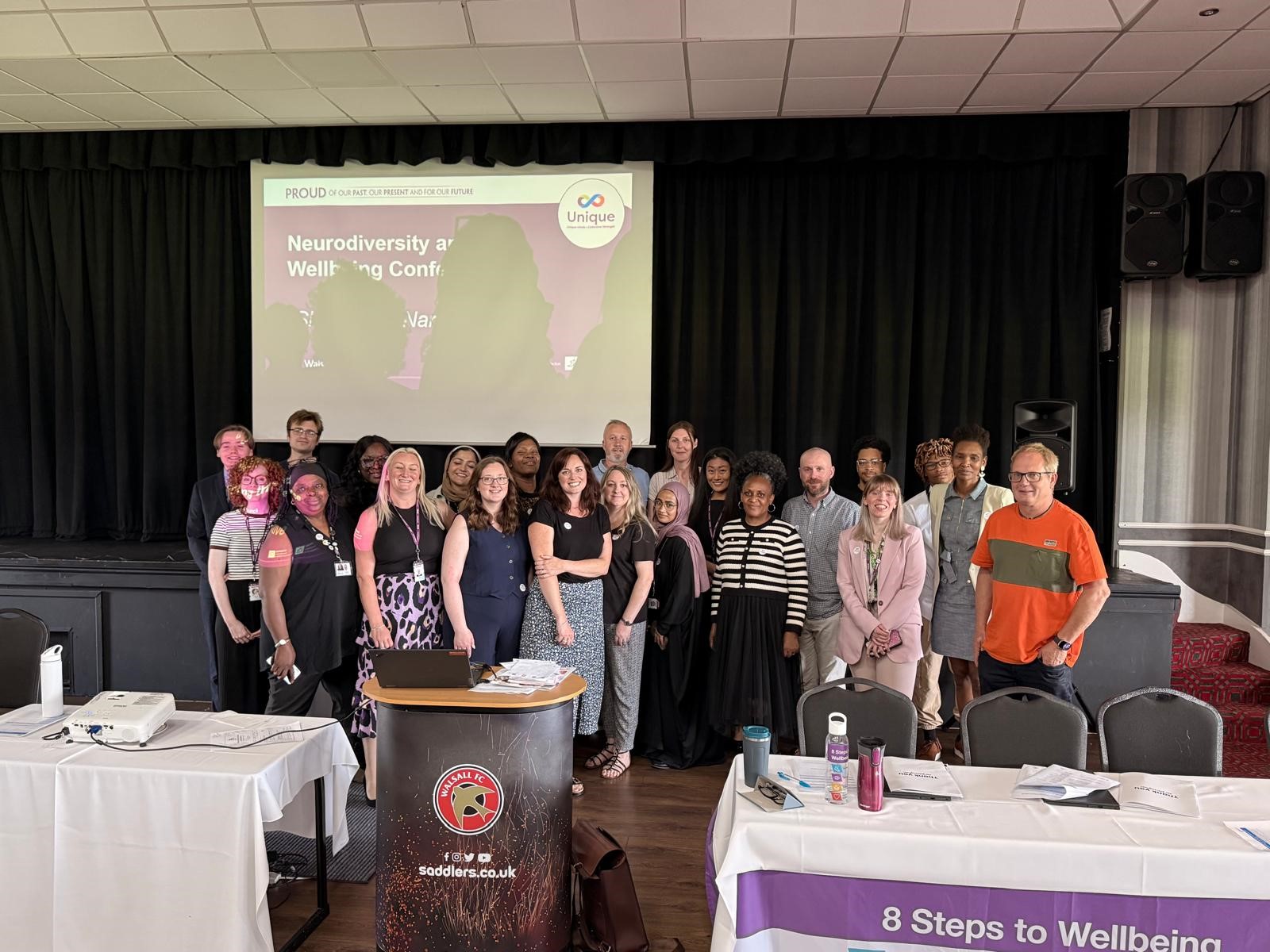 Image depicts a large group of attendees and speakers at the Neurodiversity and Wellbeing Conference.