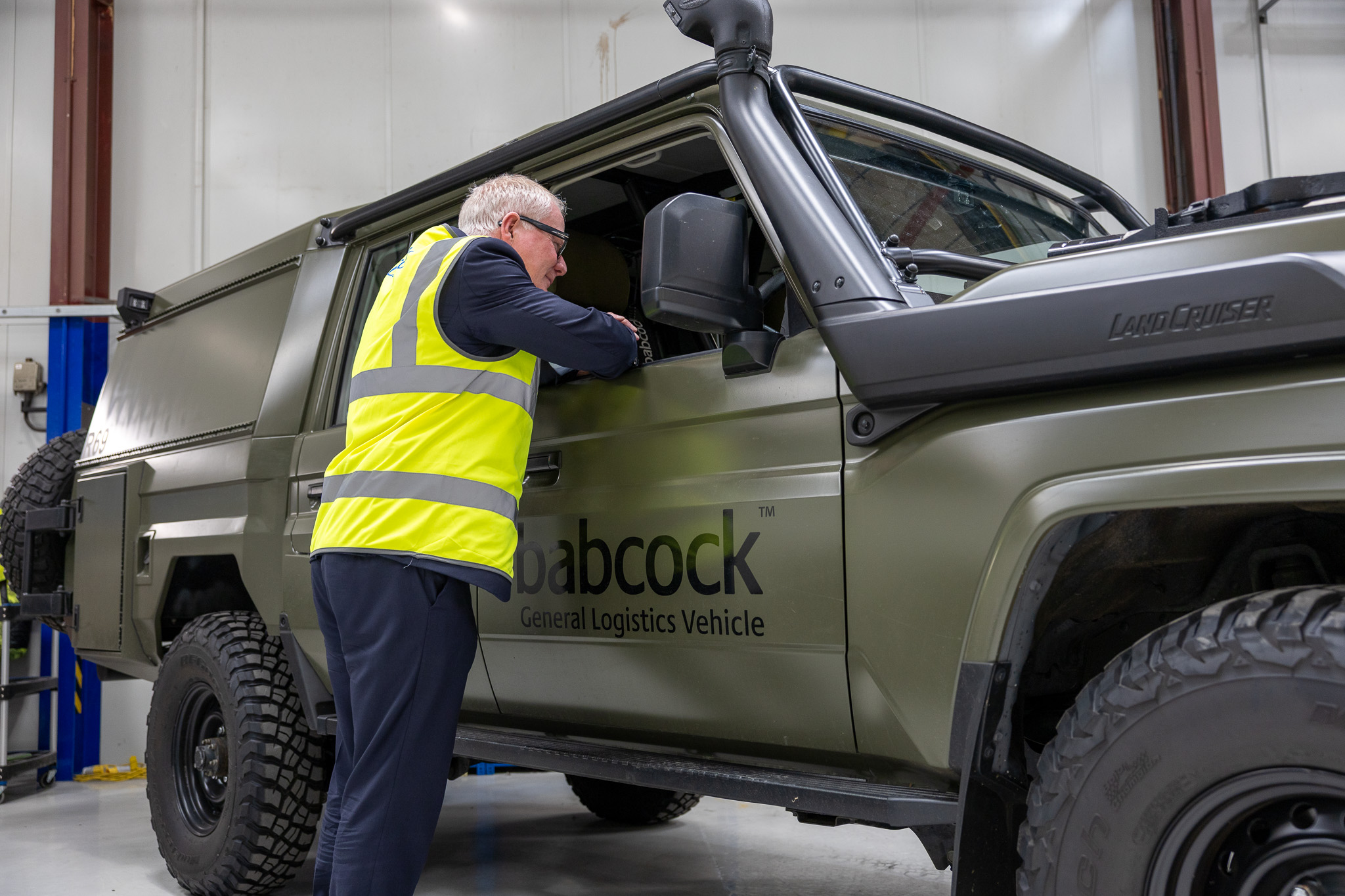 mayor richard parker looking into the window of a vehicle in a factory