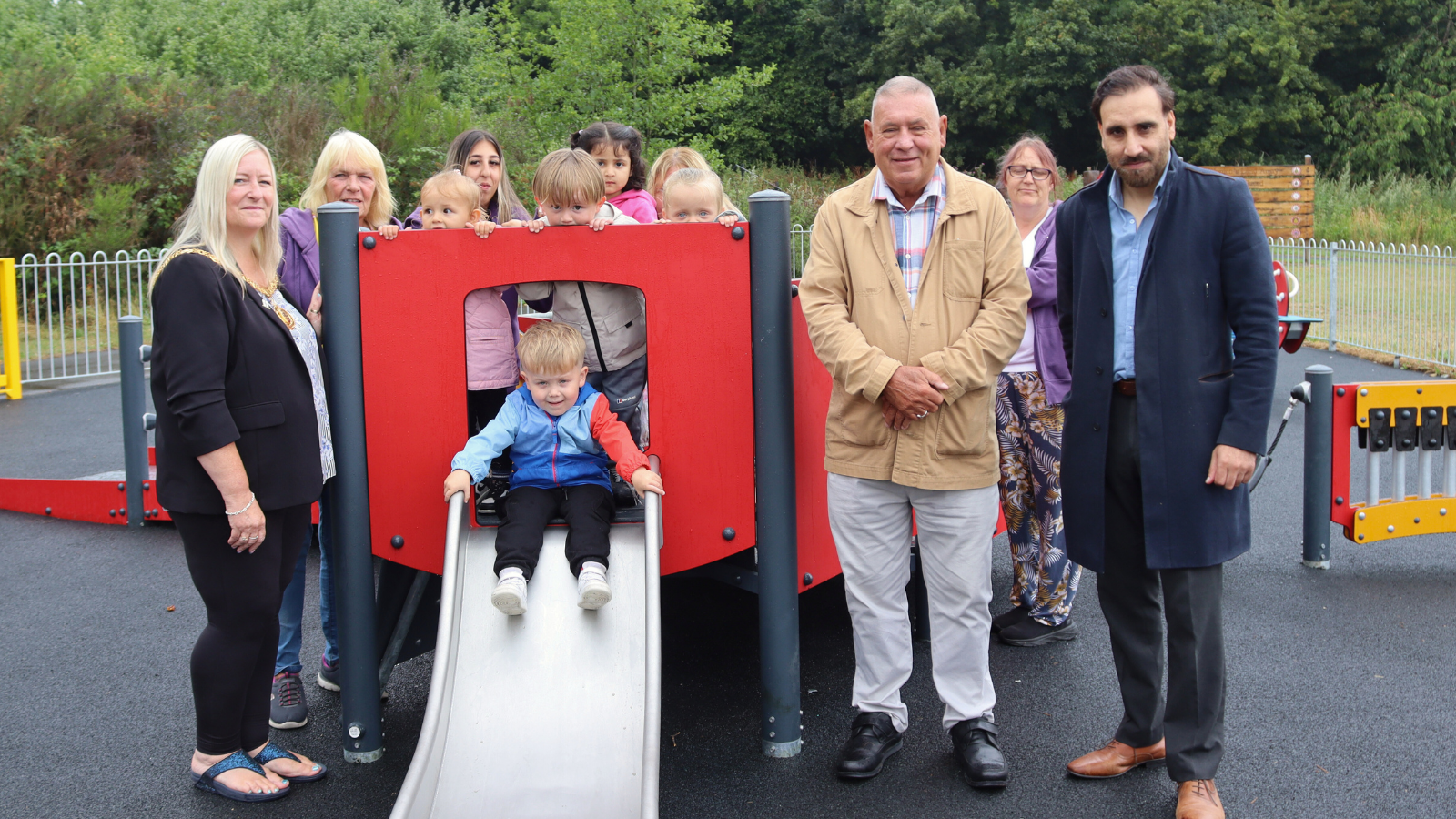 group picture on play area with child on slide