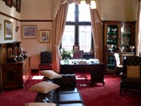 parlour room with red carpet, sofa and desk