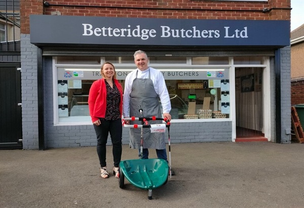 two people standing outside the butchers in betteridge