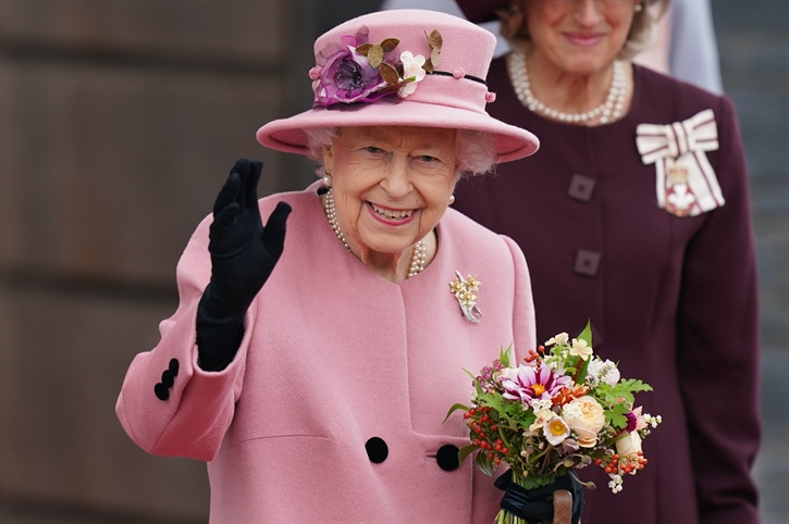 the queen wearing pink waving 