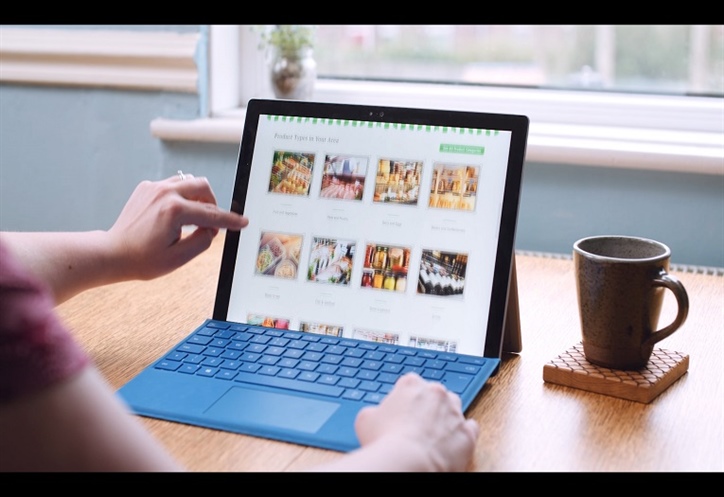 Image shows a tablet on a table, with a mug next to it.