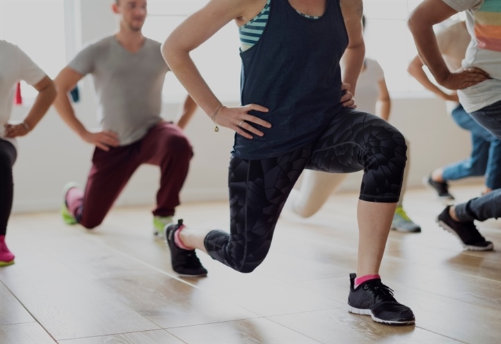 A group of people demonstrating a forward lunge