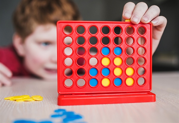 Child playing with a connect 4 game
