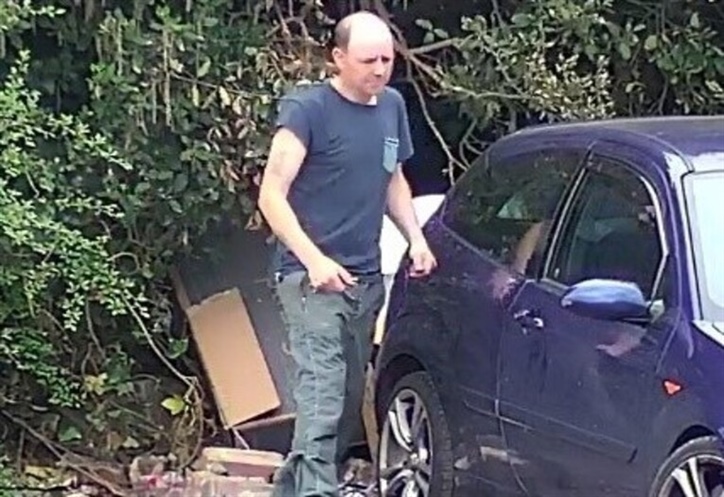white male in jeans and a blue t shirt fly tipper