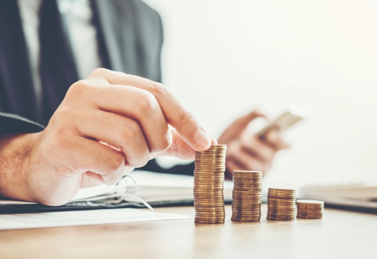 Image shows someone placing coins on a table.