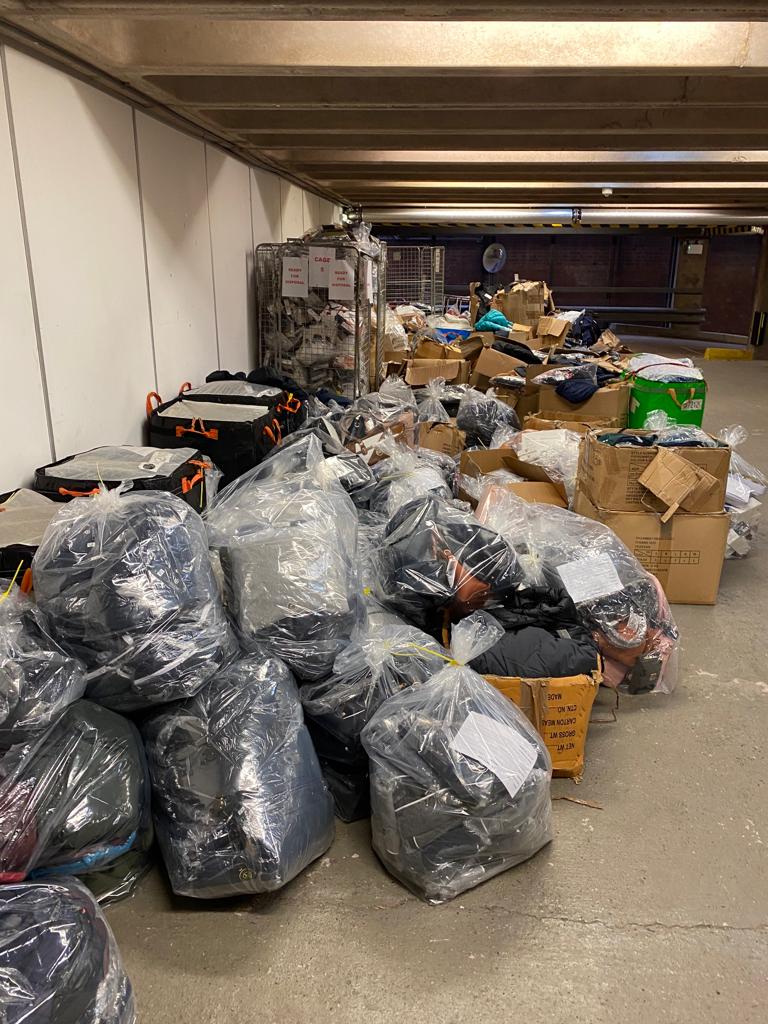 Piles of boxes and bags containing seized counterfeit goods