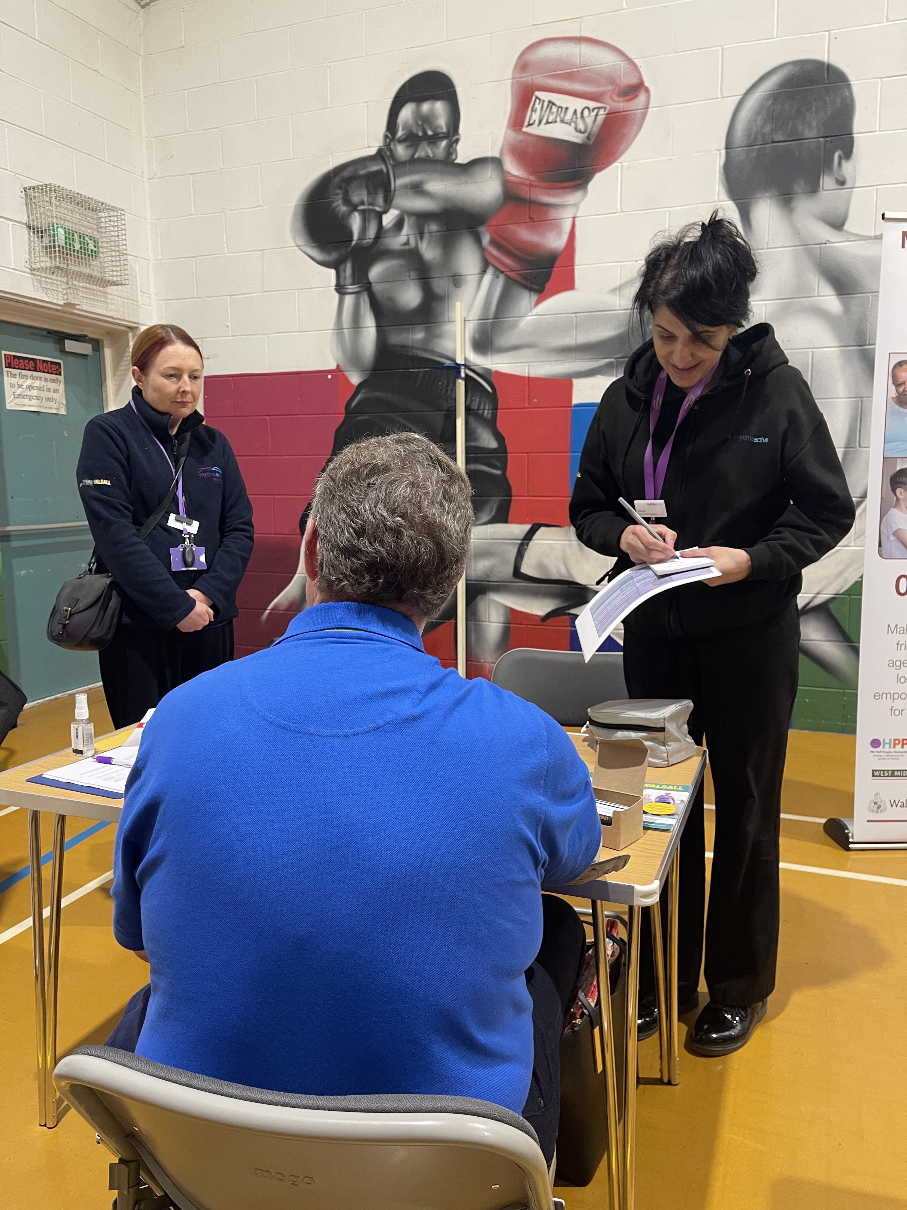 Image shows healthy lifestyle specialists undertaking a health assessment. 