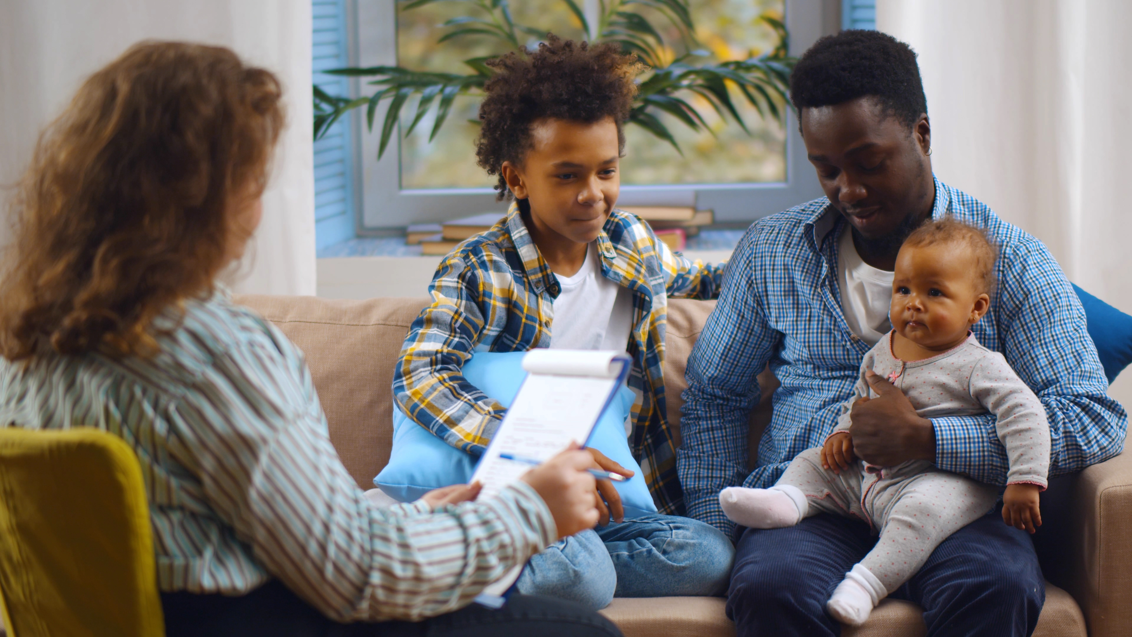 A man holding a baby having a meeting with a social worker