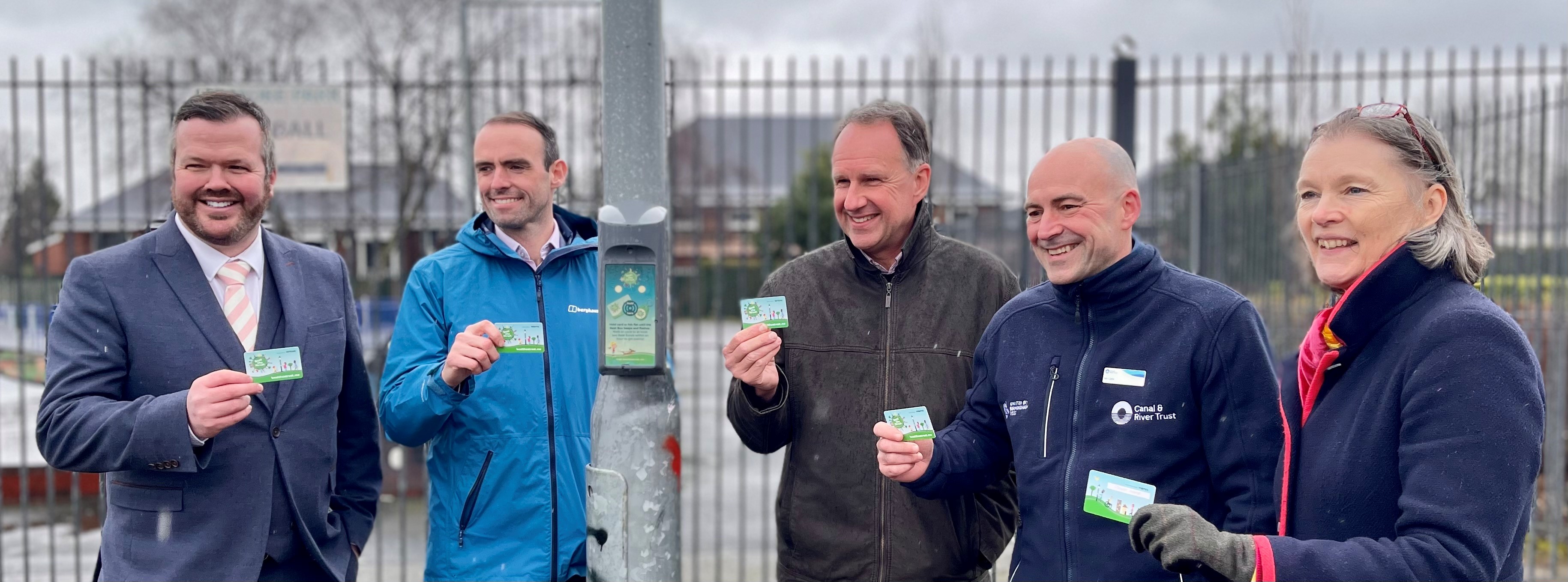 Image depicts five people holding contactless Beat the Street cards on either side of a lamppost.