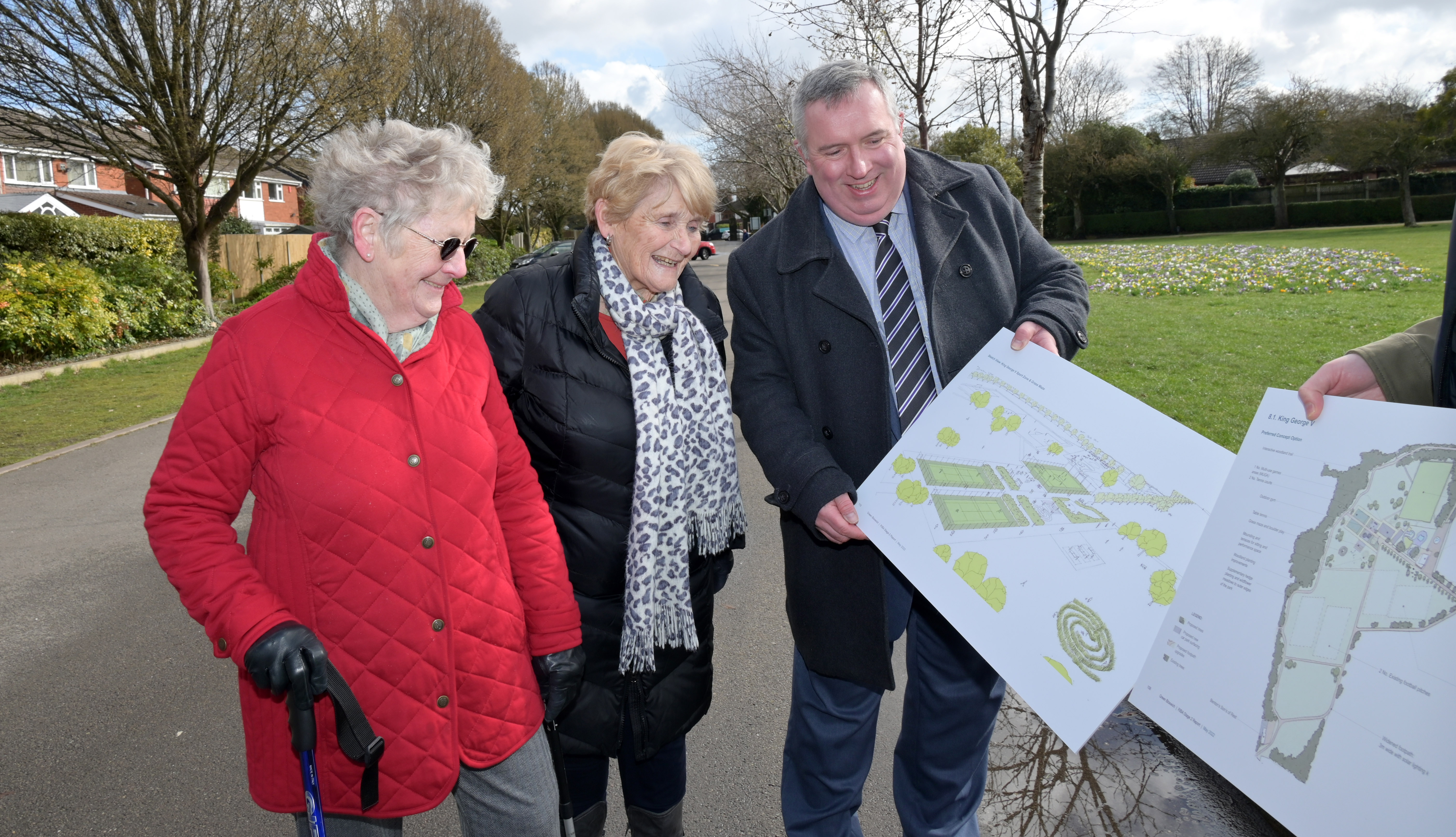 Councillor Andrew showing park improvement plans to two residents walking in the park