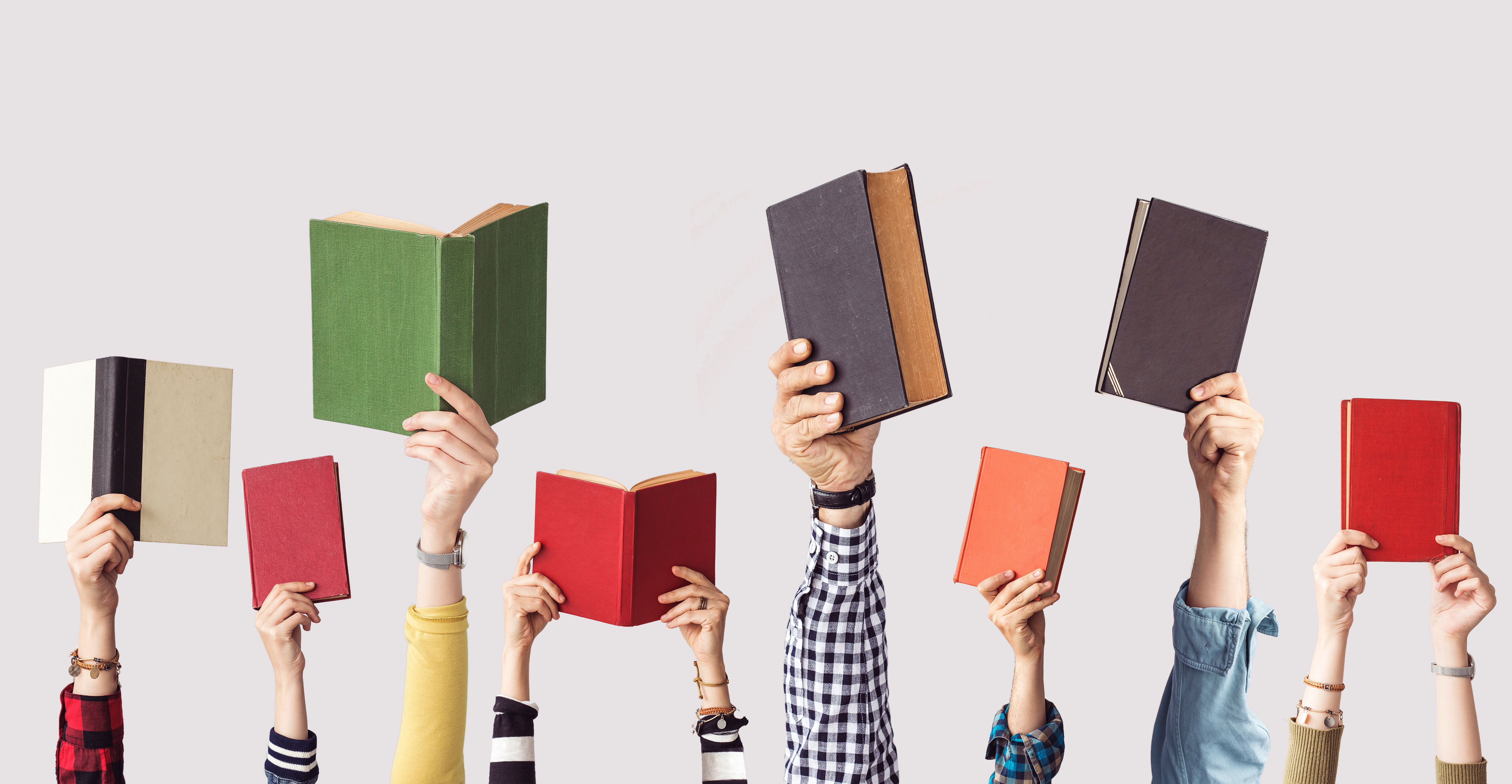 8 books being held up by people's hands