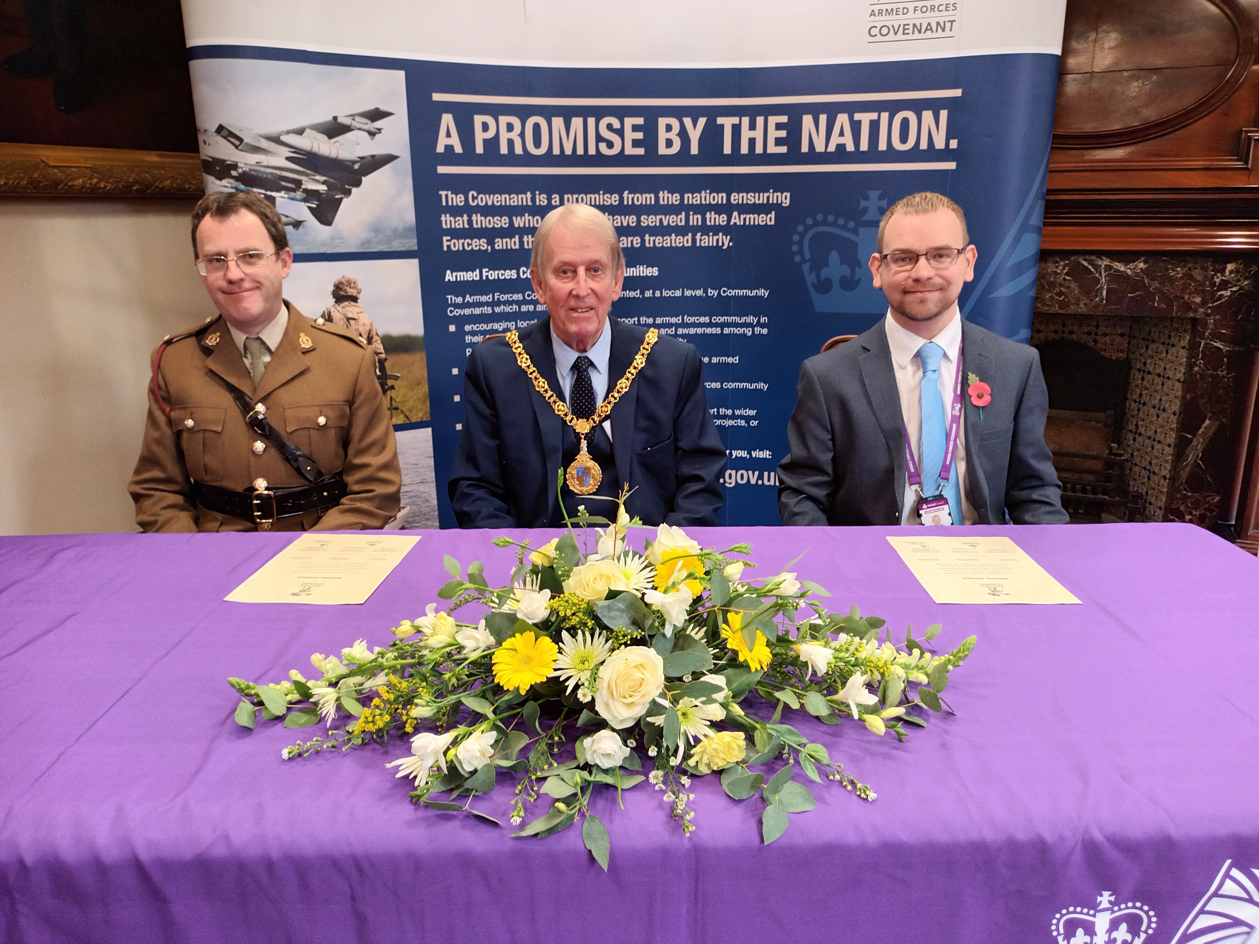 Image depicts Major Stephen Manning Councillor Chris Towe, Mayor of Walsall Councillor Adam Hicken, Walsall Council Armed Forces Champion sitting together re-signing the Armed Forces Covenant.