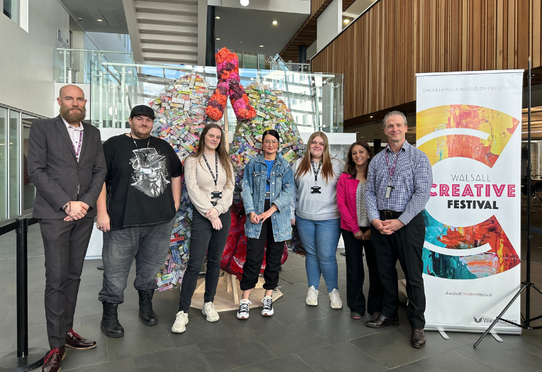 Image depicts a group of Walsall College students with Walsall Council staff in front of an art installation of a pair of lungs with a heart on display.