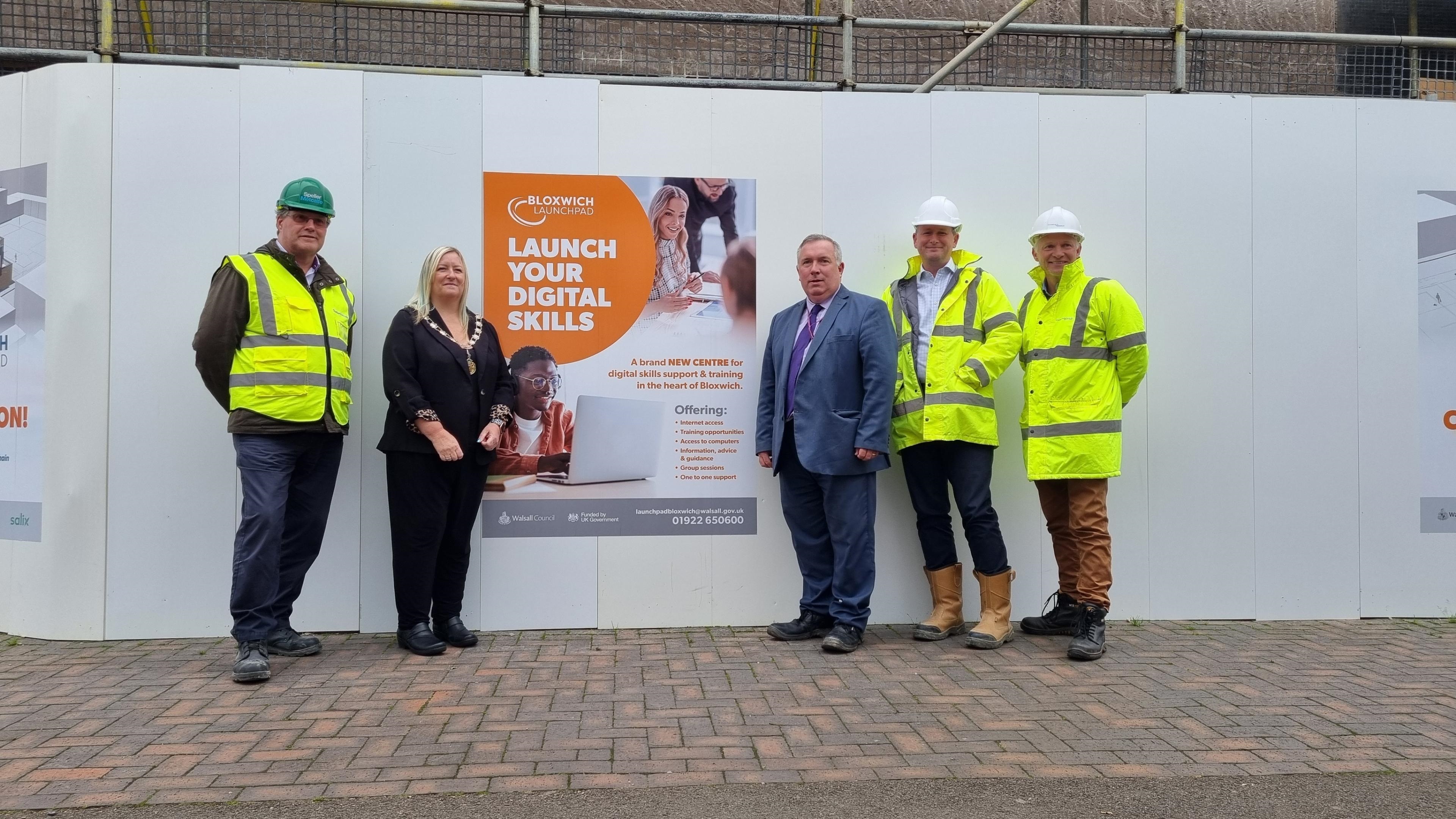 Councillor Andrew and delegates in front of advertising sign