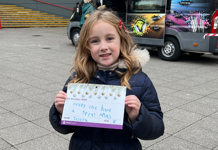 A girl holds her wish for walsall written on a card