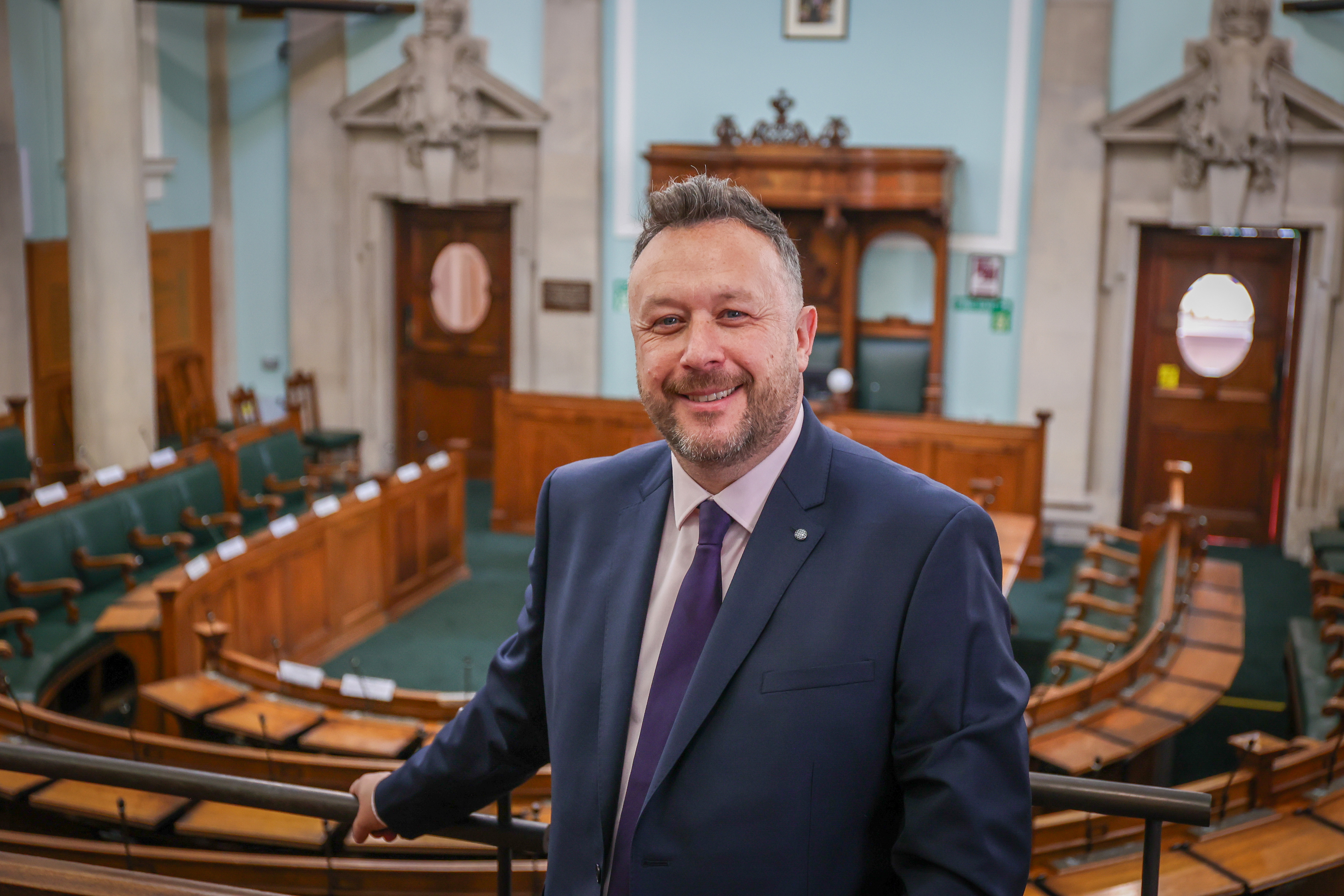 Cllr Garry Perry, smiling, with the Council Chamber in the background