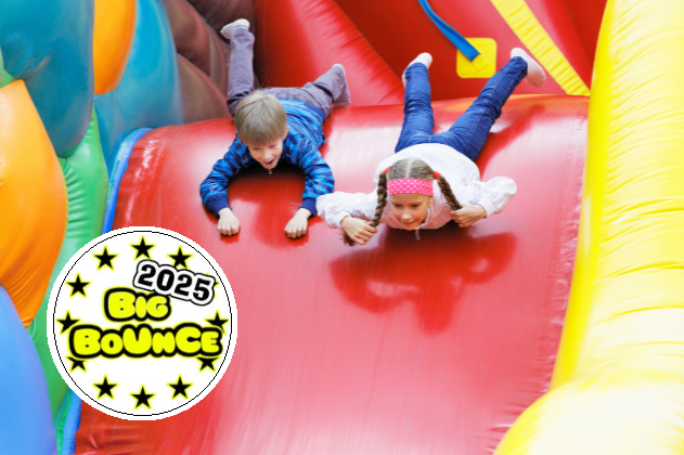 Boy and girl sliding down a red bouncy castle slide on their stomachs, with an insert big bounce in yellow text on a white circle background