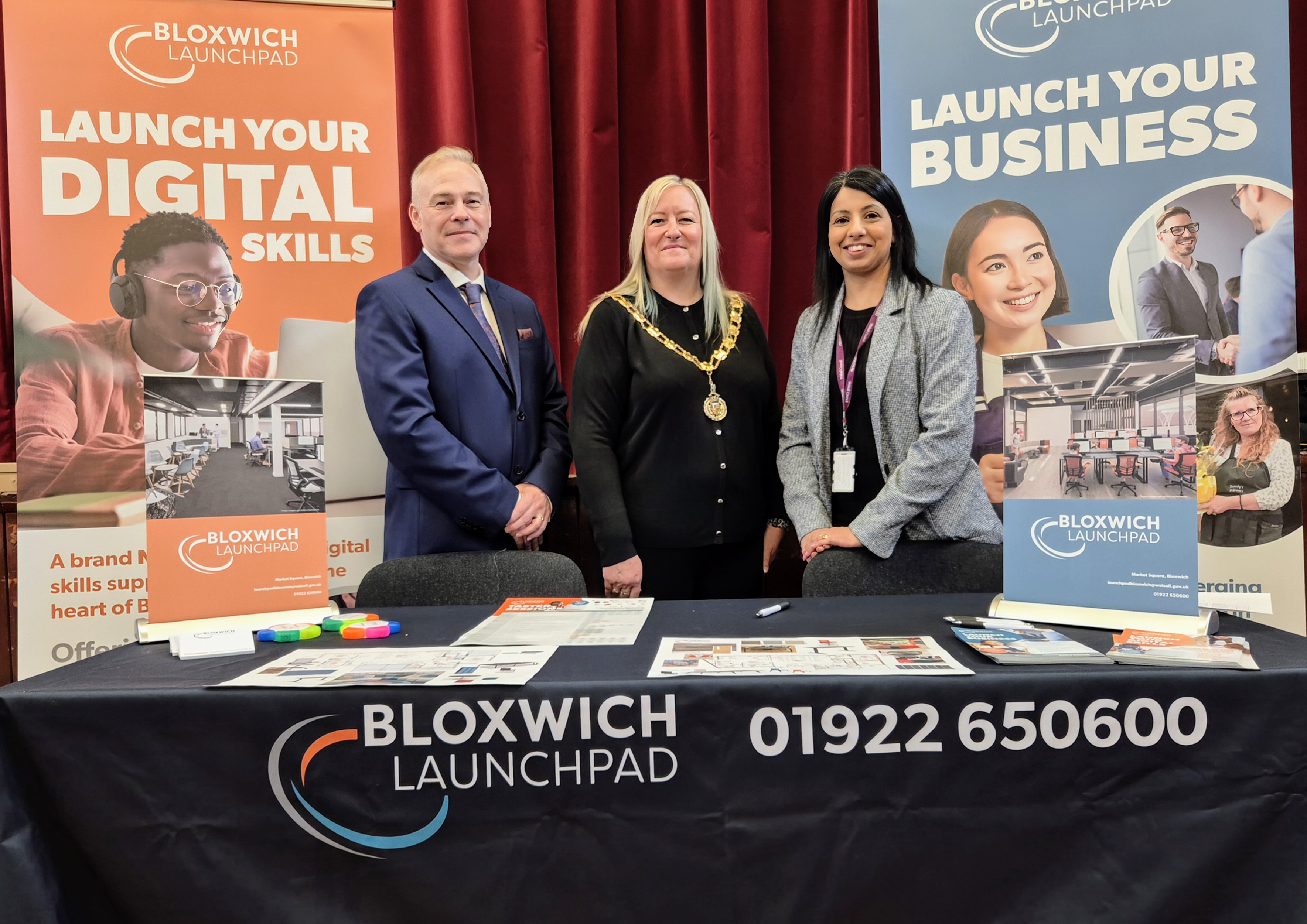 three people standing behind a Bloxwich Launchpad display table