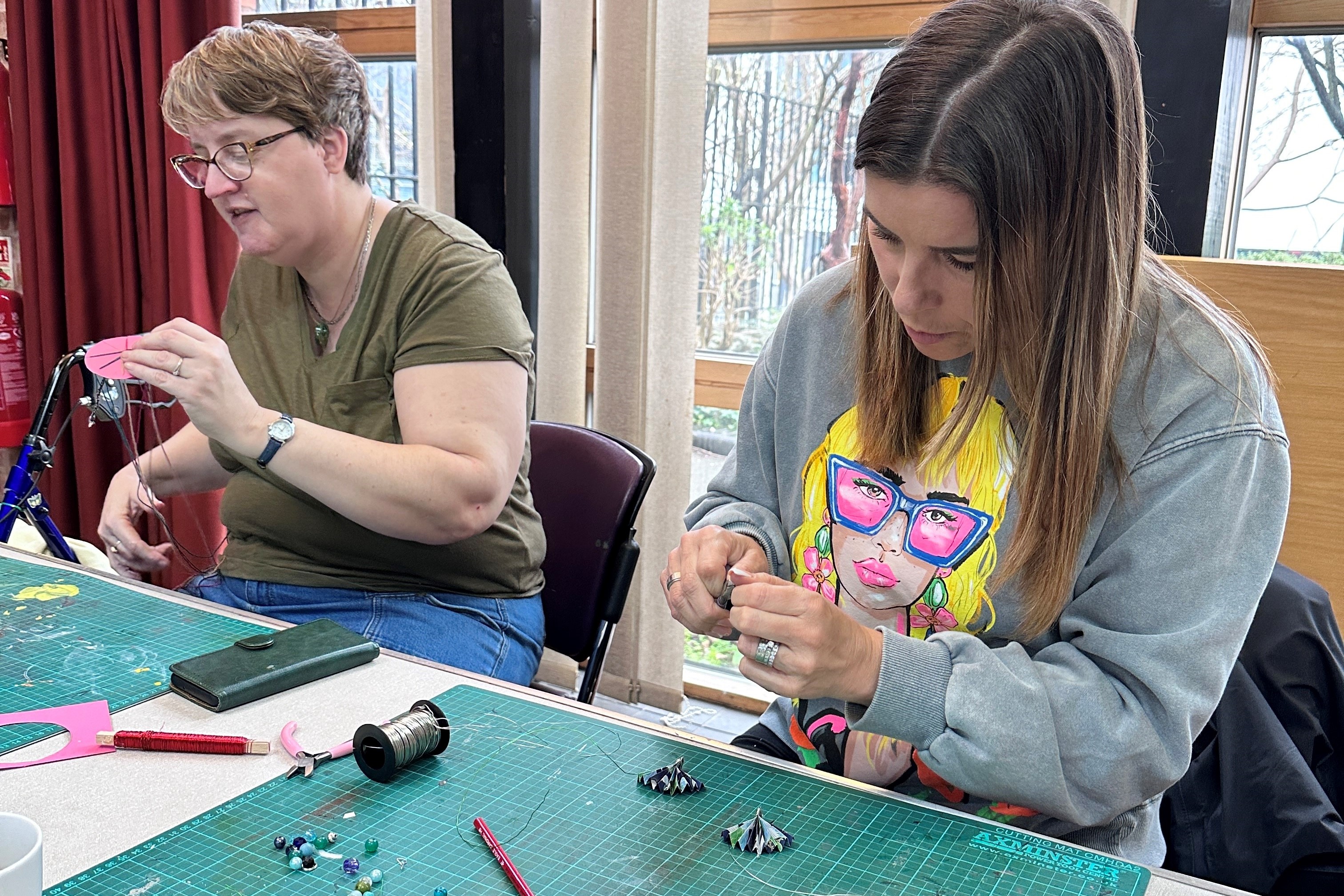 Two adults crafting at a table