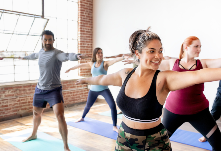 Image depicts a group of people taking part in yoga.