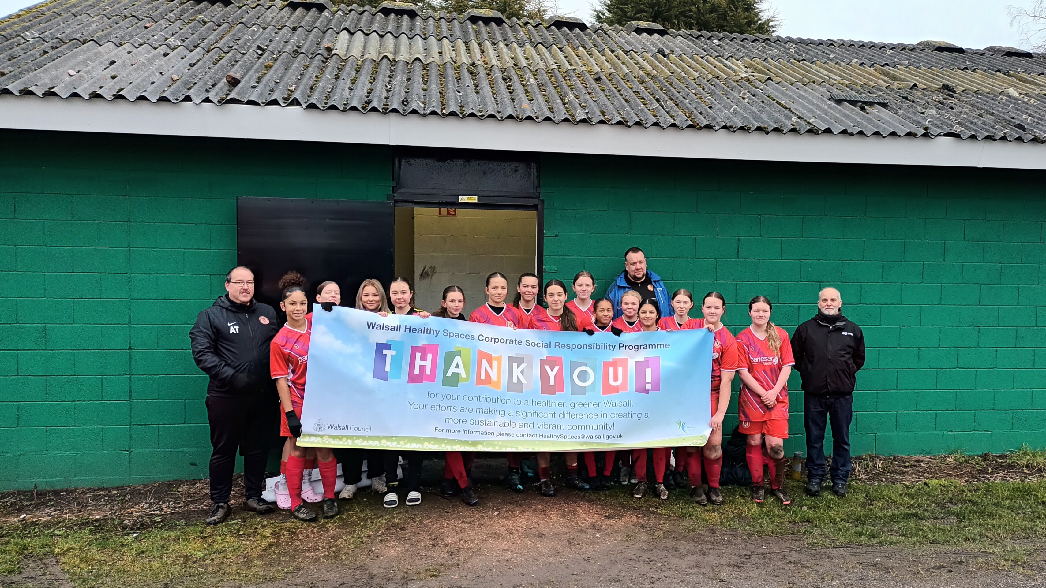 Walsall Wood Wildcats outside new changing rooms holding up sign 