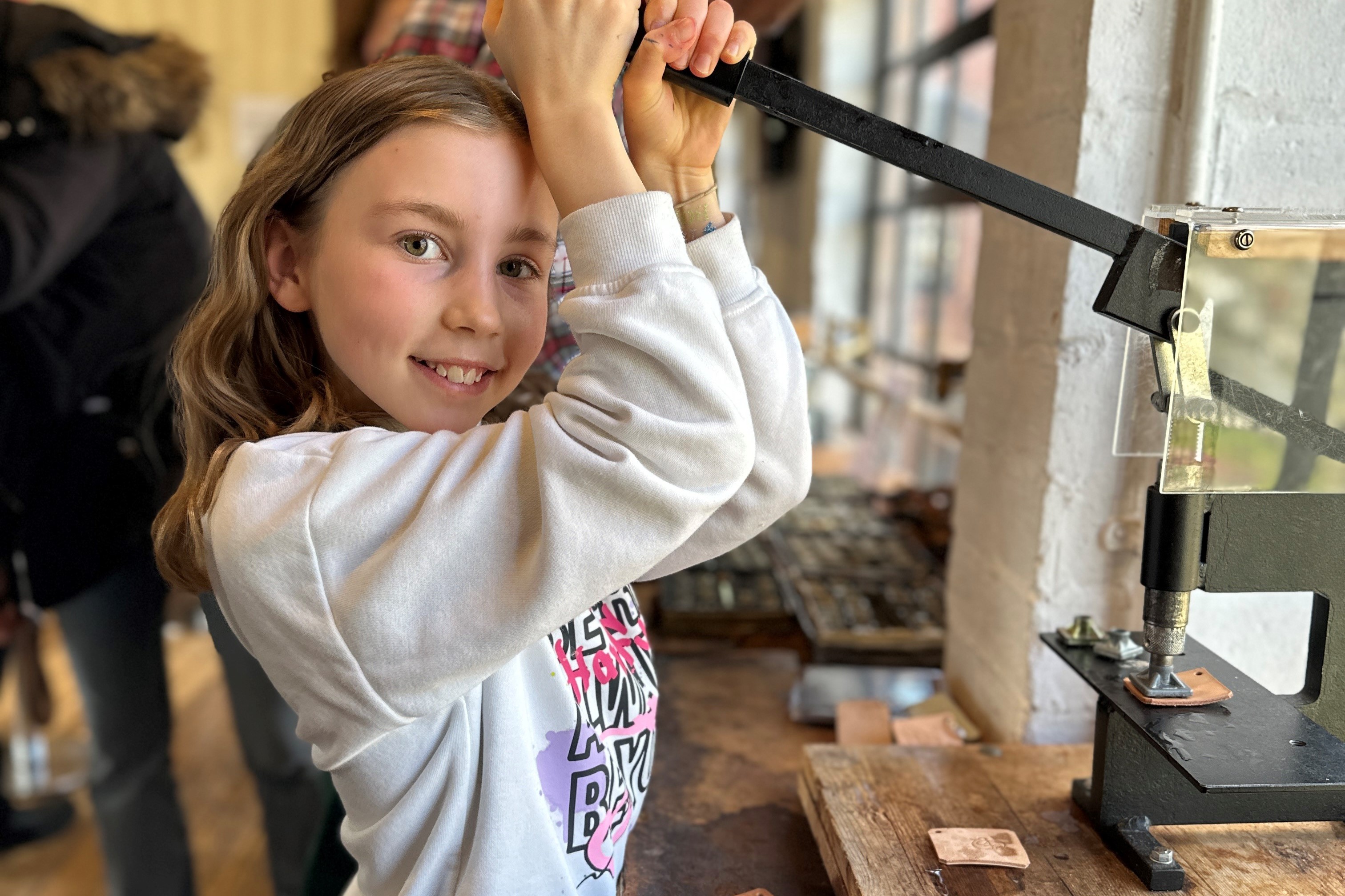 A girl using a leather stamping machine