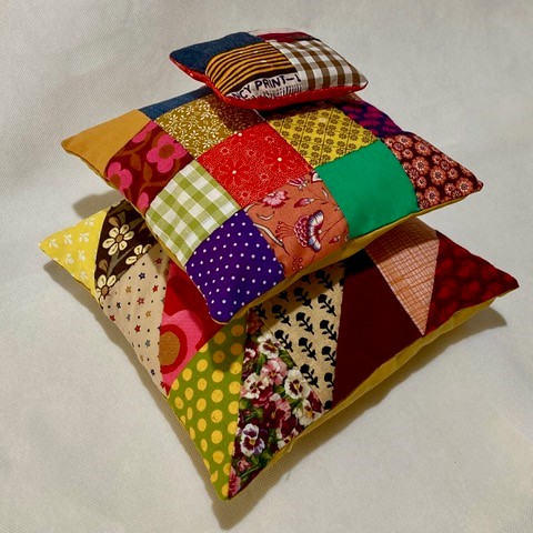 A pile of colourful patchwork fabric cushions