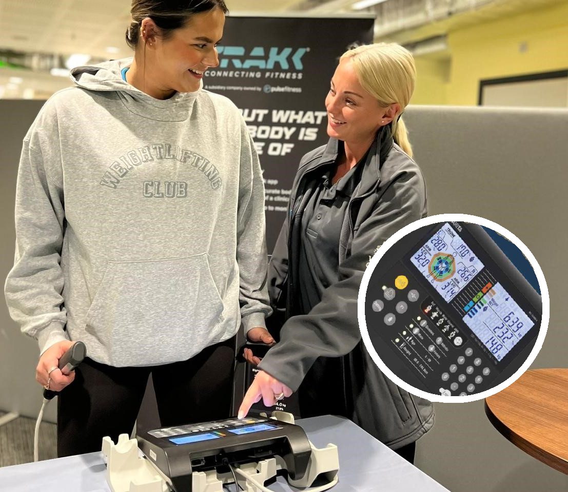 Female instructor standing with a female customer showing how to use a set of scales indoor in leisure centre reception