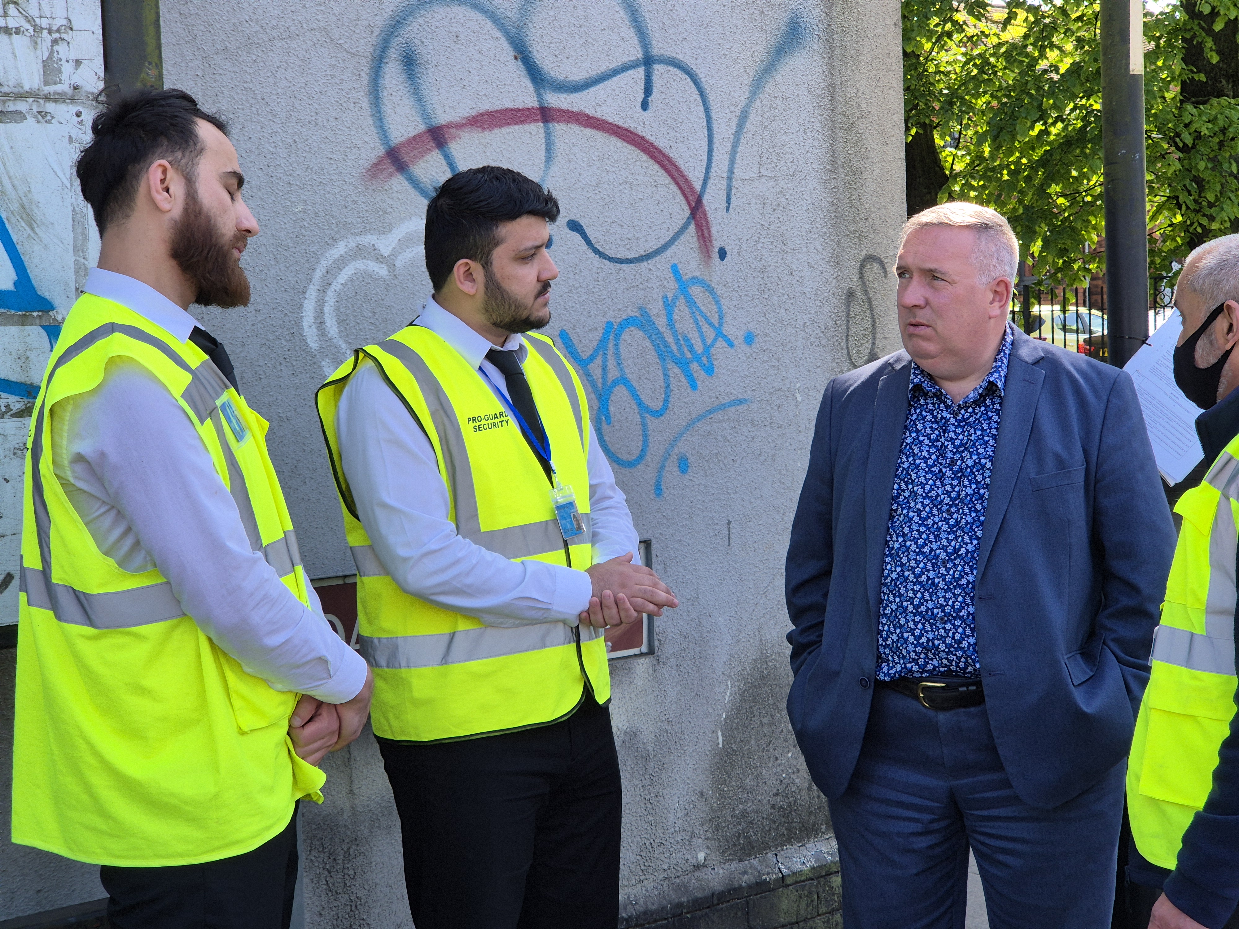 a group of four men standing beside a derelict factory