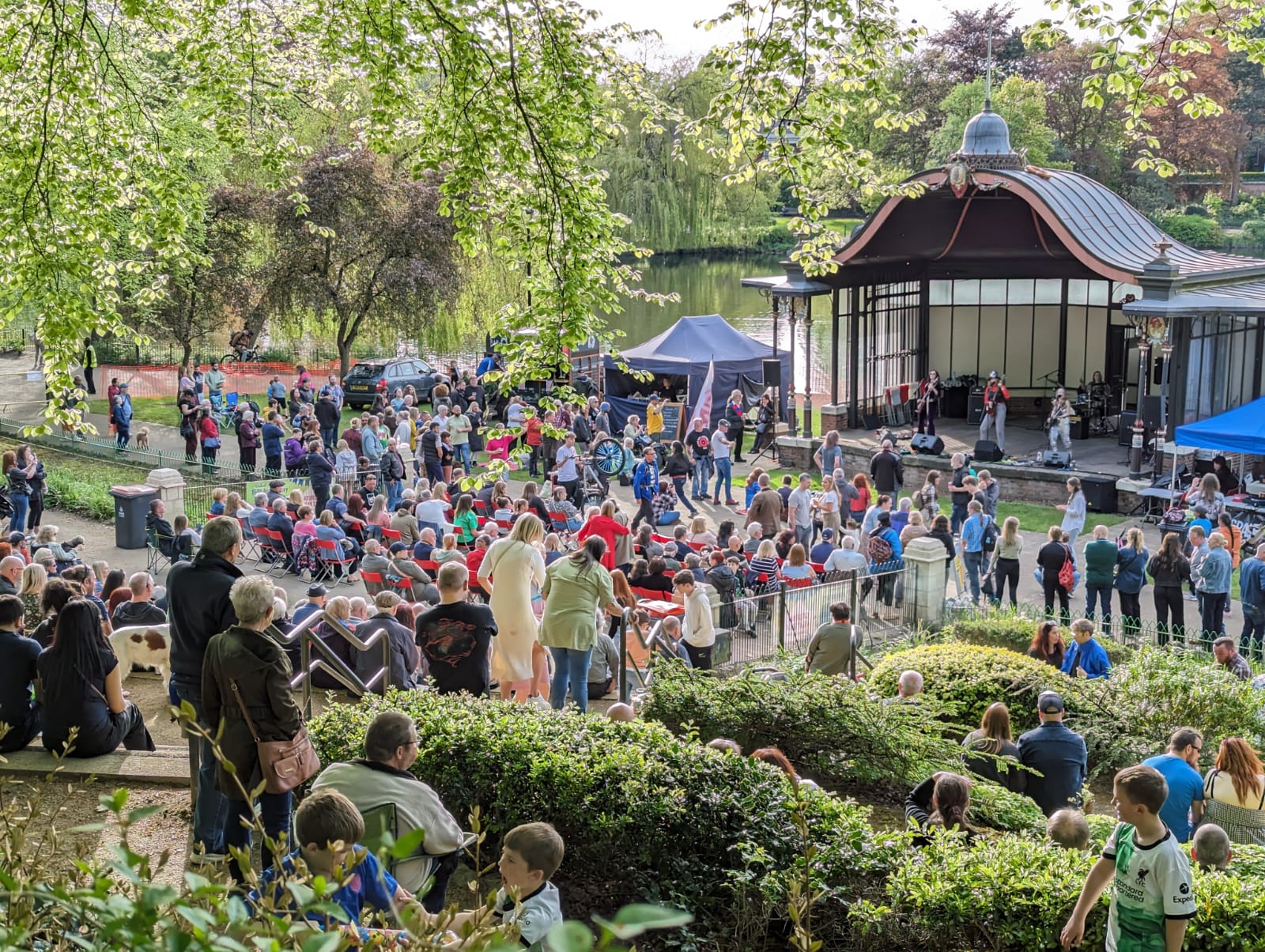 A large crowd watches a band at the bandstand in Walsall Arboretum