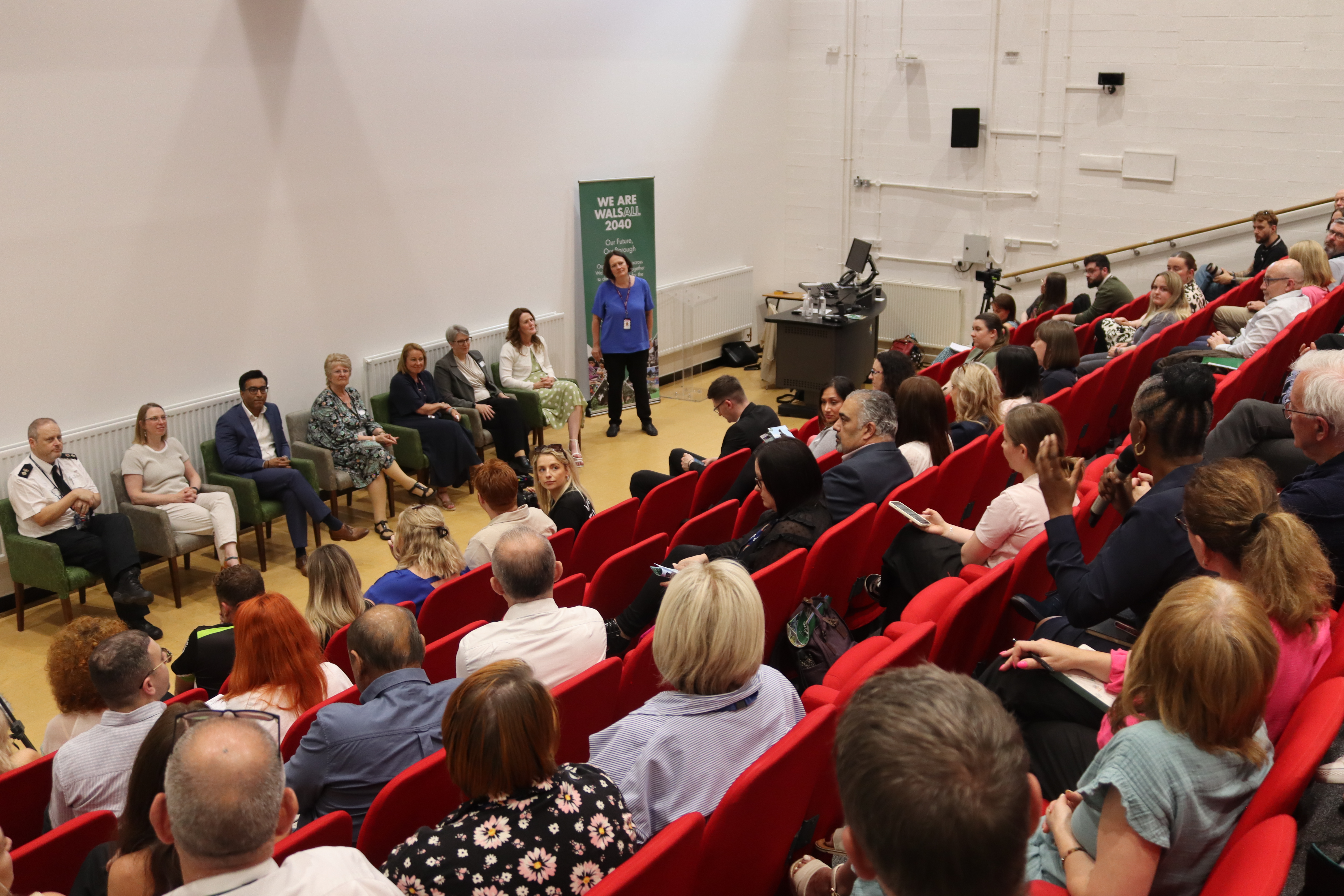 Image depicts a panel discussion at the We are Walsall 2040 conference, with an attendee asking a question.
