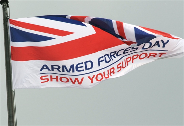 Armed Forces Day flag, with text 'show your support', on a flag pole.