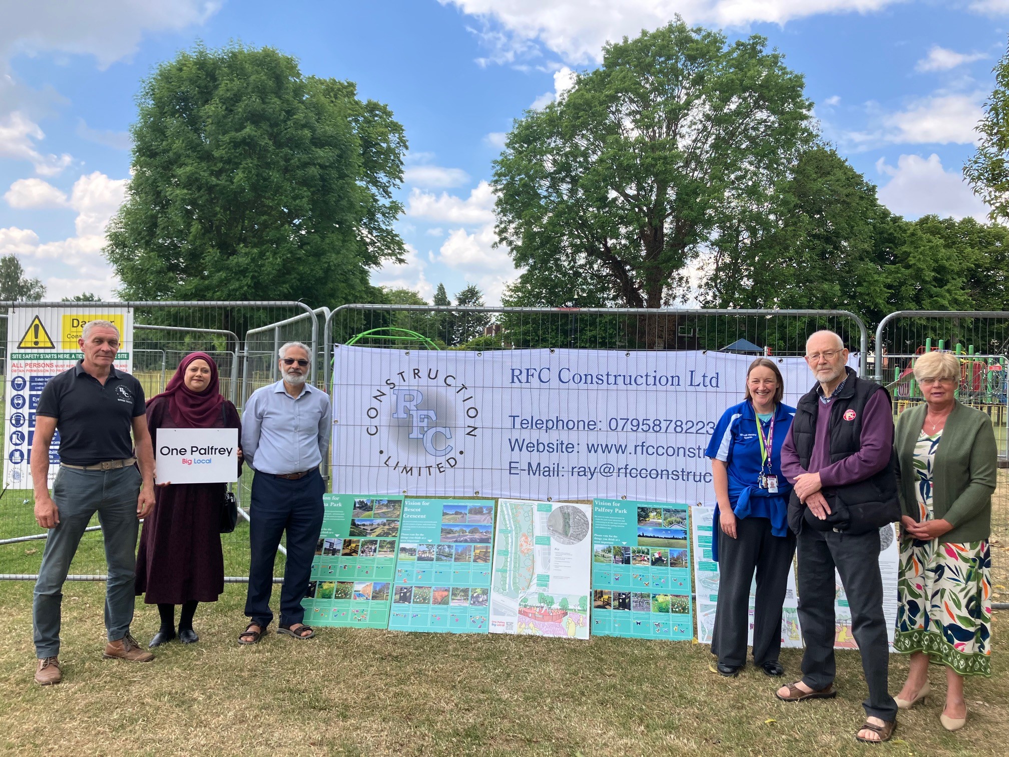 Group members outside fencing with signage 