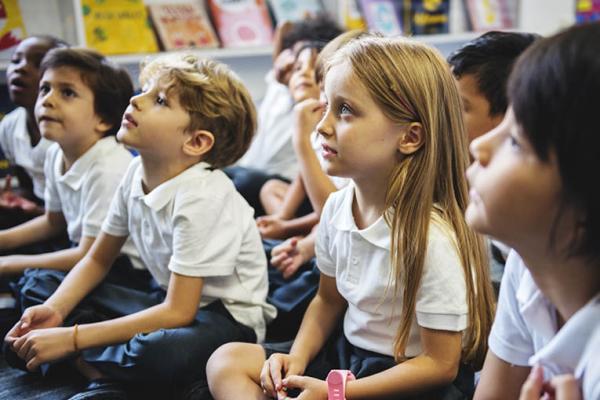 Children sitting and listening on a classroom floor