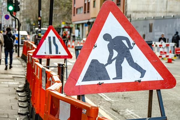 Roadworks signs between the walkway and road