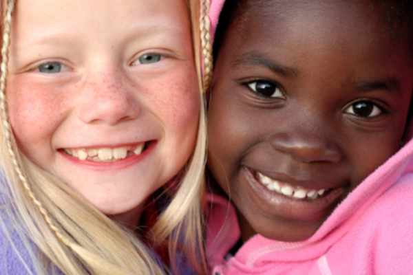 two little girls hugging and smiling