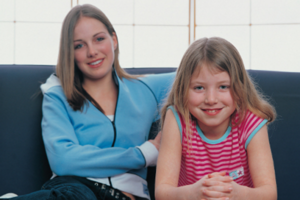 a teenager and a young girl sitting on a sofa