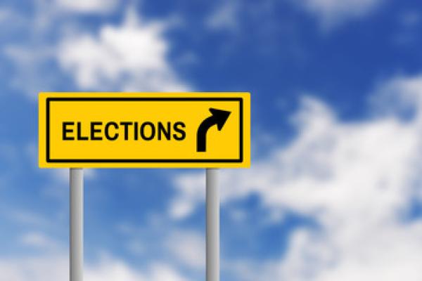 Road sign with the word "elections" and an arrow, against a blue sky