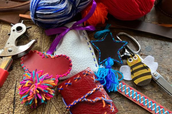 Handmade leather heart, notebook and bookmark with tools and materials for making them