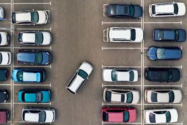 Aerial view of a car park with cars parked in spaces. One car is reversing out of a space.