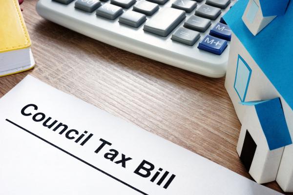 The top of a council tax bill next to a calculator on a desk