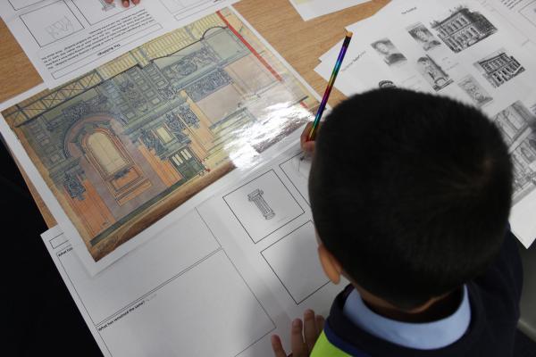 A young student looking at evidence and drawing