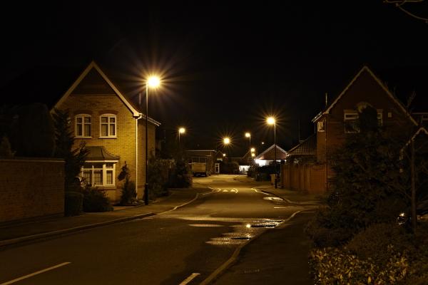 Old style street lamp illuminating the road and the area around it