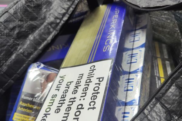 blue and gold boxes of illegal cigarettes inside a black bag