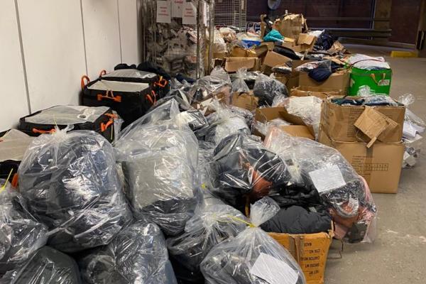 Piles of boxes and bags containing seized counterfeit goods