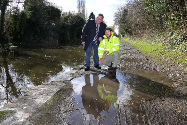 Councillor Andrew standing next to James Dennison on a muddy canal towpath 